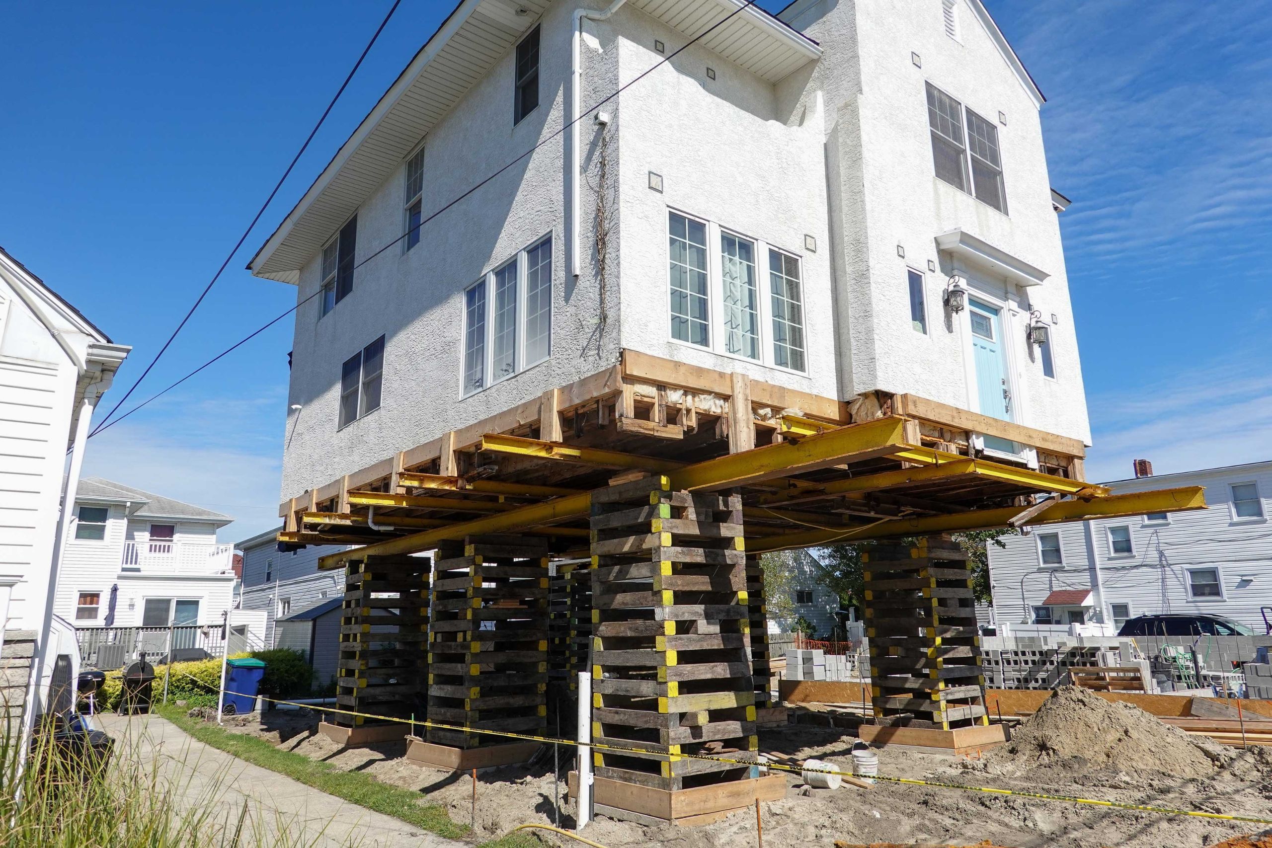 A team of professionals using specialized equipment to raise a house in Palm Beach, preparing it for elevation and renovation